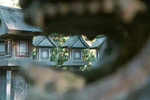 Stone lanterns framed through an irregular opening in the foreground